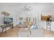 Well-lit living room features a large sectional sofa, entertainment center, and an open layout to the dining area at 13235 Essman Ave, Port Charlotte, FL 33953
