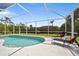 Relaxing screened-in pool area with lounge chairs to soak up the Florida sun at 13235 Essman Ave, Port Charlotte, FL 33953