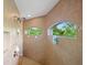 Tiled shower with dual showerheads and twin windows with views of the green and natural exterior at 13235 Essman Ave, Port Charlotte, FL 33953