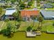 Beautiful waterfront home featuring a private dock, pool, and lush landscaping with palm trees at 149 Albert Ln, Port Charlotte, FL 33954