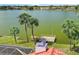 Home offers a backyard view of the lake with a small dock and mature palm trees at 149 Albert Ln, Port Charlotte, FL 33954