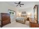 Bedroom with neutral walls, carpet, ceiling fan, window, and dark-wood furniture at 149 Albert Ln, Port Charlotte, FL 33954