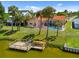 A view of the pool, private dock, and lush lawn leading to the waterfront property at 149 Albert Ln, Port Charlotte, FL 33954