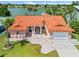 Beautifully landscaped single Gathering home with a red tile roof, paver driveway, and mature palm trees on the water at 149 Albert Ln, Port Charlotte, FL 33954