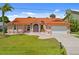 Beautiful single Gathering home with terracotta roof, manicured lawn, and charming curb appeal at 149 Albert Ln, Port Charlotte, FL 33954