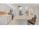 Well-lit kitchen with white cabinetry, modern appliances, and a central island with bar stools at 149 Albert Ln, Port Charlotte, FL 33954