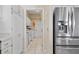 White kitchen area with stainless steel refrigerator leading to laundry room at 149 Albert Ln, Port Charlotte, FL 33954