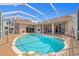 Expansive pool area with a screened enclosure and brick deck, perfect for outdoor entertaining and relaxation at 149 Albert Ln, Port Charlotte, FL 33954