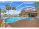 A large pool with a screened-in enclosure and brick deck, providing stunning views of the waterfront at 149 Albert Ln, Port Charlotte, FL 33954