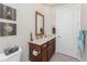 Neutral bathroom with dark wood vanity, accent wall decor, and decorative towels at 15762 Aqua Cir, Port Charlotte, FL 33981