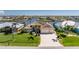 Waterfront home with a beautiful tile roof, paved driveway, manicured lawn, and tropical landscaping at 15762 Aqua Cir, Port Charlotte, FL 33981