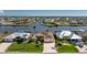 Waterfront home with a lush green lawn, paved driveway, mature palm trees, and convenient boat dock at 15762 Aqua Cir, Port Charlotte, FL 33981