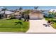 Stunning home featuring an oversized driveway, manicured lawn, and tropical landscaping in a desirable neighborhood at 15762 Aqua Cir, Port Charlotte, FL 33981