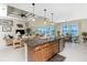 Kitchen with granite island overlooking living room, screened patio, and pool with water views at 15762 Aqua Cir, Port Charlotte, FL 33981