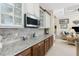 Kitchen with granite countertops, stainless microwave, wood cabinets and tile backsplash overlooking the living area at 15762 Aqua Cir, Port Charlotte, FL 33981