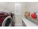 Convenient laundry room with modern washer/dryer units and storage shelves at 15762 Aqua Cir, Port Charlotte, FL 33981