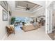 Bright, open-concept living space with wicker furniture and sliding glass doors to the outdoor lanai at 15762 Aqua Cir, Port Charlotte, FL 33981