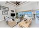 Cozy living room featuring wicker furniture, neutral tones, and a view of the screened lanai with waterfront at 15762 Aqua Cir, Port Charlotte, FL 33981
