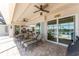 An open-concept outdoor patio features lounge chairs, a dining set, brick flooring, and partial views of the pool at 15762 Aqua Cir, Port Charlotte, FL 33981