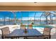 A screened patio boasts a pool with a waterfront view and a dining set for outdoor enjoyment at 15762 Aqua Cir, Port Charlotte, FL 33981