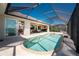 A screened pool is surrounded by brick flooring with a view into the open interior of the property at 15762 Aqua Cir, Port Charlotte, FL 33981