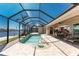 A screened pool has brick flooring and a canal view, along with access to the home's patio at 15762 Aqua Cir, Port Charlotte, FL 33981