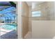 Walk-in shower with a window and tile surround sits next to a pool with a view at 15762 Aqua Cir, Port Charlotte, FL 33981