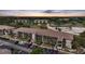 Aerial view of condo buildings, mature trees, parking and lush grounds as the sun sets at 175 Kings Hwy # 226, Punta Gorda, FL 33983