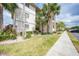 Well-maintained condo building with lush landscaping, sidewalks, and parking area on a clear day at 175 Kings Hwy # 226, Punta Gorda, FL 33983