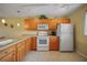 Open concept kitchen featuring white appliances and light wood cabinets and tile flooring at 175 Kings Hwy # 226, Punta Gorda, FL 33983