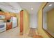 Kitchen with adjacent hall and entry door and white appliances and light wood cabinets at 175 Kings Hwy # 226, Punta Gorda, FL 33983