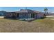 Backyard with enclosed pool, screened patio, and grassy yard at 18106 Petoskey Cir, Port Charlotte, FL 33948