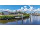 Backyard view of a home with a wooden dock extending onto the water at 18106 Petoskey Cir, Port Charlotte, FL 33948