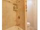 Neutral tiled bathroom with shower-tub combination and decorative accent tiles at 18106 Petoskey Cir, Port Charlotte, FL 33948