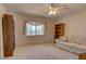 Bright carpeted bedroom with ceiling fan, large window, and bookshelf at 18106 Petoskey Cir, Port Charlotte, FL 33948