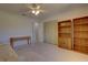 Bright carpeted bedroom with ceiling fan, closet and bookshelf at 18106 Petoskey Cir, Port Charlotte, FL 33948