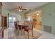 Open dining room features a ceiling fan, tile floors, and a view into the kitchen and sun room at 18106 Petoskey Cir, Port Charlotte, FL 33948