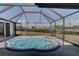 Enclosed backyard spa with see-through screen enclosure at 18106 Petoskey Cir, Port Charlotte, FL 33948