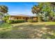 Expansive backyard with lush greenery, palm trees, and a screened-in patio for outdoor enjoyment at 2192 Hyatt Dr, Port Charlotte, FL 33948