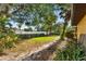 Well-maintained backyard featuring mature trees, lush landscaping, and a white fence at 2192 Hyatt Dr, Port Charlotte, FL 33948