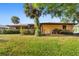 Spacious backyard featuring a well-maintained lawn, mature landscaping, and a charming exterior at 2192 Hyatt Dr, Port Charlotte, FL 33948