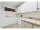 Bright laundry room features a utility sink, cabinets, and a window for natural light at 2192 Hyatt Dr, Port Charlotte, FL 33948