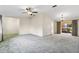 Expansive living room with plush carpet, ceiling fan, and sliding door access to the outside at 2192 Hyatt Dr, Port Charlotte, FL 33948
