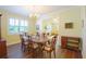 Dining room featuring elegant chandelier, wood floors, open to living room, and large window at 2227 Bonn Ct, Punta Gorda, FL 33983