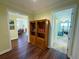 Hallway with wood floors leading to rooms, with a bookshelf as a focal point at 2227 Bonn Ct, Punta Gorda, FL 33983