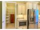 A pantry with adjustable shelving for organized storage, next to the stainless steel refrigerator at 2227 Bonn Ct, Punta Gorda, FL 33983