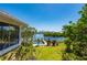 View of the canal from the backyard, showing a dock, lush landscaping, and the side of the home at 24139 Jolly Roger Blvd, Punta Gorda, FL 33955