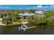 Aerial view of the backyard with a private dock along the canal in a lush, waterfront setting at 24139 Jolly Roger Blvd, Punta Gorda, FL 33955