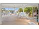 An inviting covered patio featuring ample dining space with ceiling fans, white furniture, and a waterfront view at 24139 Jolly Roger Blvd, Punta Gorda, FL 33955