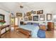 Bright bedroom with multiple artworks, hardwood floors, and bench at 24139 Jolly Roger Blvd, Punta Gorda, FL 33955